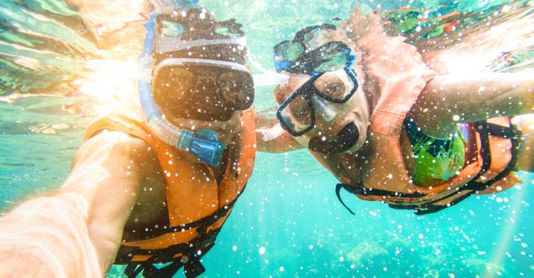 Viajeros haciendo snorkel en la Laguna Azul